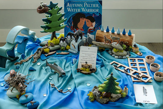 Nature-based water learning setup with wooden toys, animal figures, and sensory materials arranged for hands-on classroom exploration