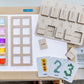 5 and 10 frame with Indigenous Language Numbers Puzzle and Seasonal Numbers Cards on a light table with acrylic cubes