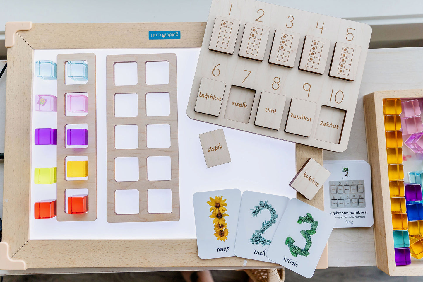 5 and 10 frame with Indigenous Language Numbers Puzzle and Seasonal Numbers Cards on a light table with acrylic cubes