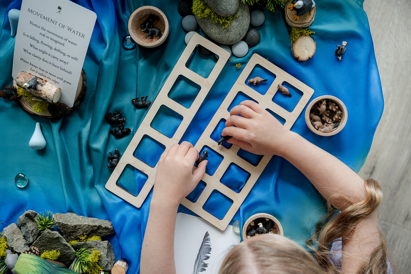 Child using Ocean Invitation to Play learning collection to sort and pattern wooden animal figures, supporting hands-on math and early years learning