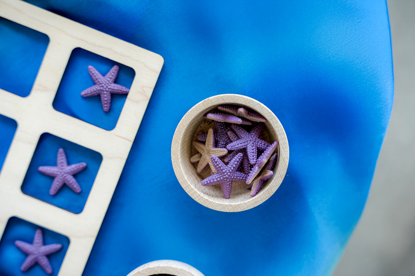 Close-up of wooden sorting tray and starfish counters from Ocean Invitation to Play learning collection for hands-on math and sensory learning in early years classrooms