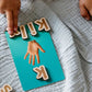 Child using Living Language Alphabet cards and wooden letters for hands-on word building and language learning